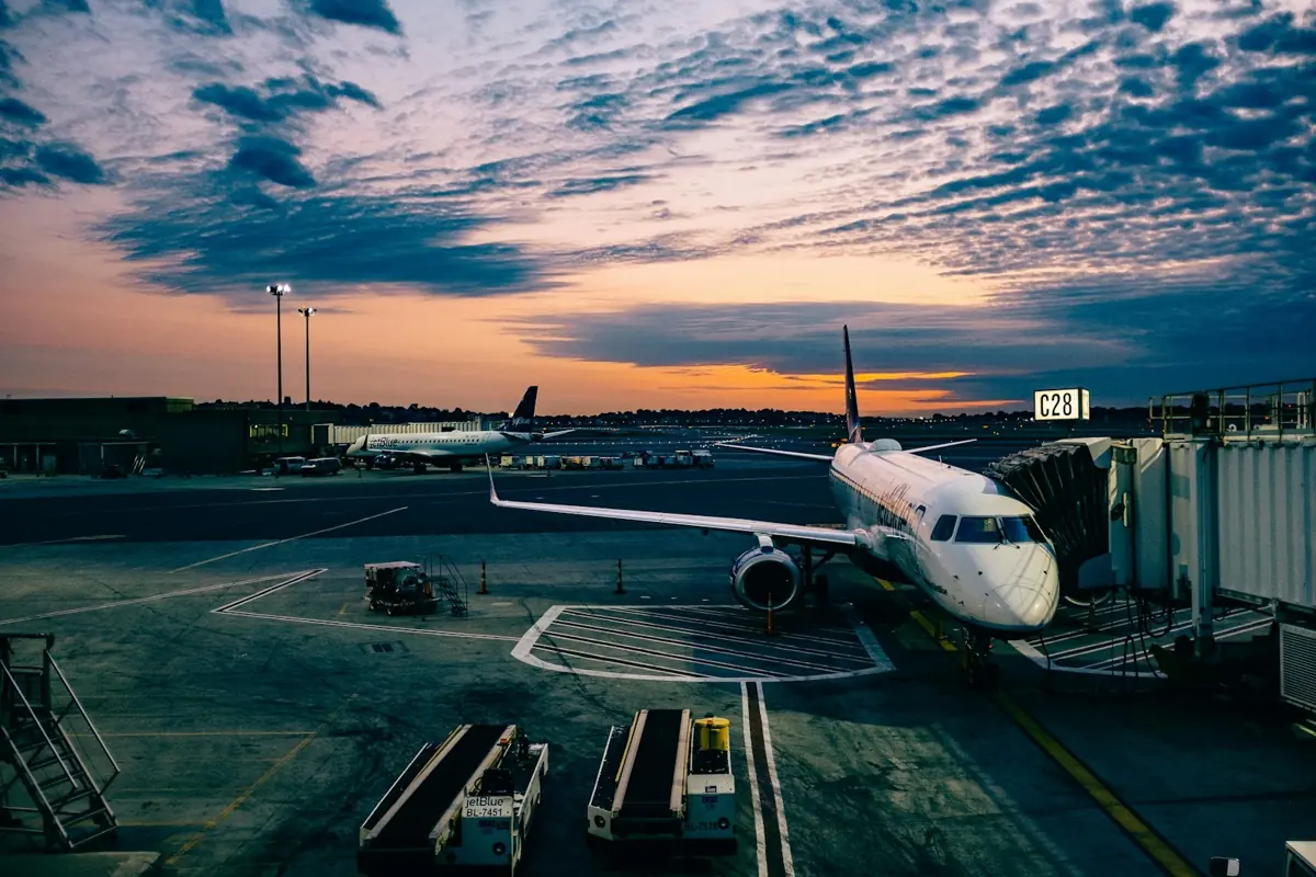 A passenger jet at the gate at sunset